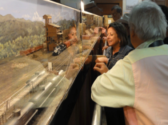 Board Member Sam Furukawa explains the diorama to a fascinated New Mexico Governor Susana Martinez on her visit to the C&TS on Opening Day, some years back. She and her husband spent longer than planned at the Center, fascinated by the videos and diorama.